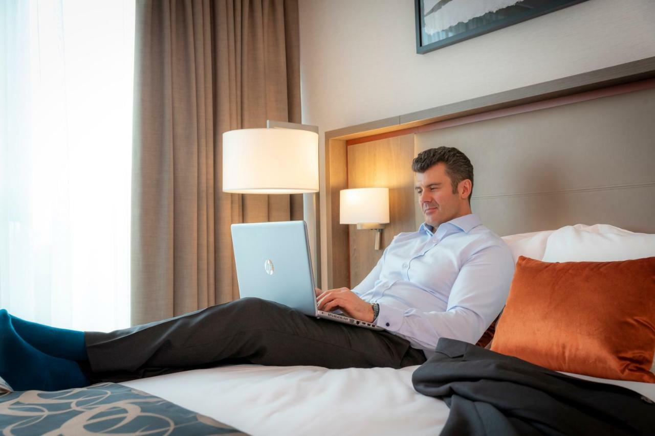Clayton Hotel Dublin Airport Coolock Bagian luar foto A man working on a laptop in a hotel room